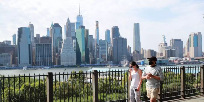 Passanten tragen Schutzmasken und gehen in einem Park im New Yorker Stadtteil Brooklyn spazieren. Coronavirus - USA