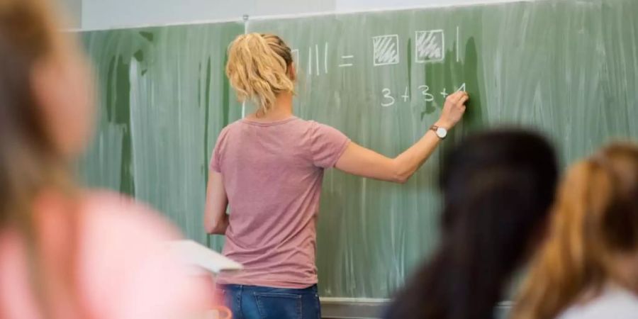 Eine junge Lehrerin beim Unterricht. Foto: Julian Stratenschulte/dpa