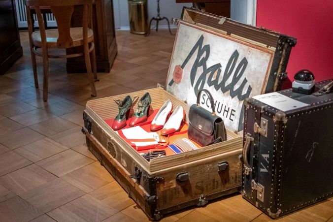Ein alter Reisekoffer mit Artikeln von Bally-Schuhe.