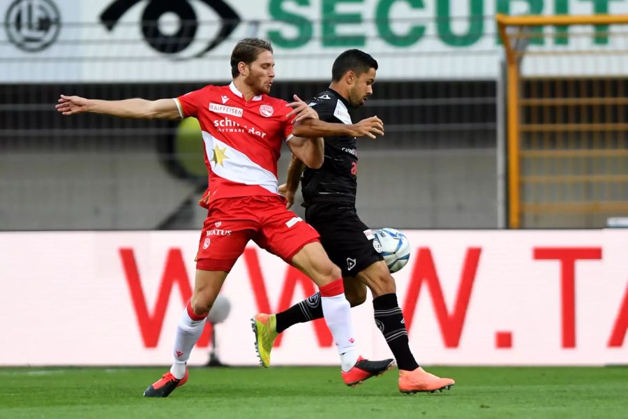 Luganos Jonathan Sabbatinikämpft gegen Thuns Nicolas Hasler um den Ball.