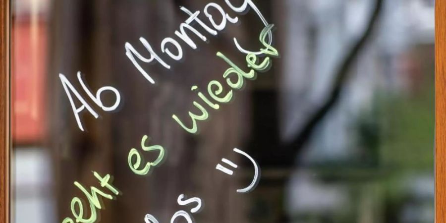 Mit den Worten «Ab Montag geht es wieder los» im Schaufenster kündigt ein Geschäft in Frankurt am Main die Öffnung an. Foto: Frank Rumpenhorst/dpa