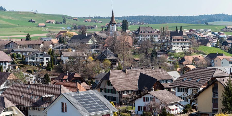 Blick auf Biglen mit der evangelisch-reformierten Kirche, dem Gemeindehaus und dahinter dem Bären.