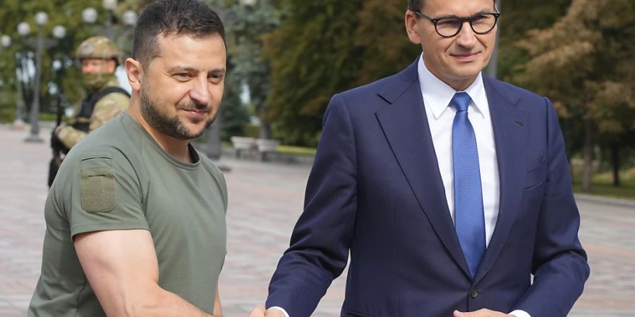 Wolodymyr Selenskyj (l), Präsident der Ukraine, und Mateusz Morawiecki, Ministerpräsident von Polen, schütteln einander während eines Treffens die Hand. Foto: Efrem Lukatsky/AP/dpa