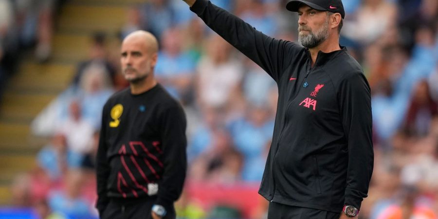 City-Trainer Pep Guardiola (l) und Liverpools Coach Jürgen Klopp stehen an der Seitenlinie.