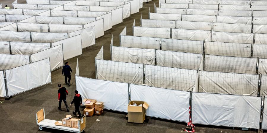 Arbeiter bereiten eine Messehalle in Hamburg für die Unterbringung von Menschen aus der Ukraine vor. Dort sollen kurzfristig rund 400 Vertriebene Schutz finden.