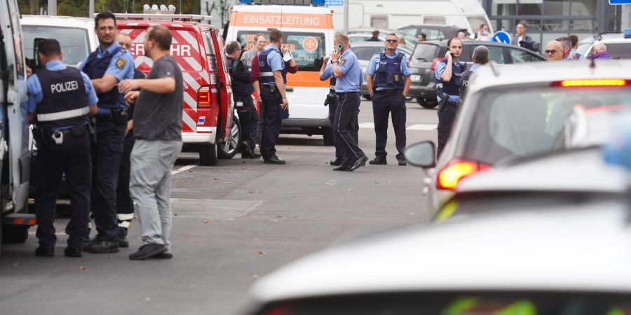 Polizisten und Rettungskräfte stehen an einem der Tatorte in Ludwigshafen.