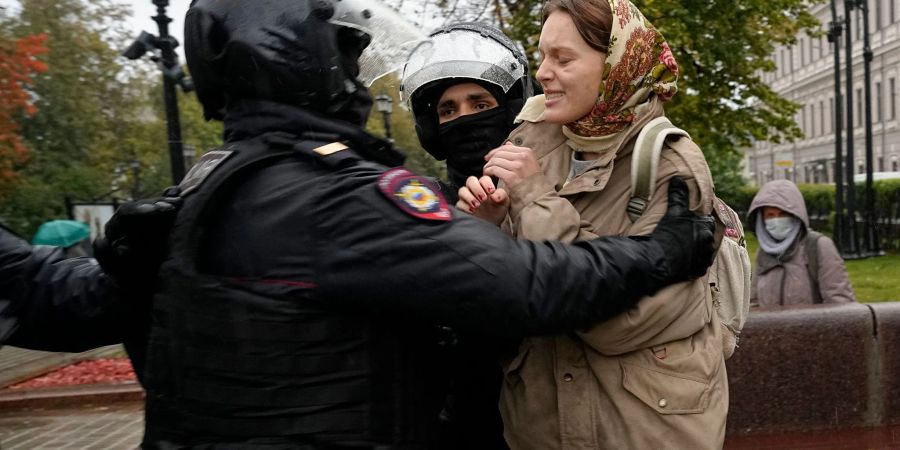 Polizisten nehmen bei Protesten in Moskau eine Frau fest.