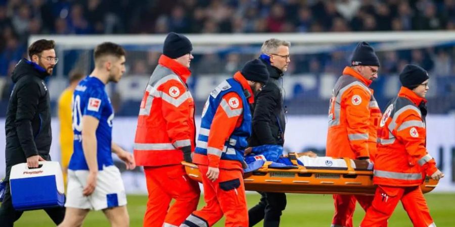 Schalkes Weston McKennie muss nach einem Zweikampf mit Frankfurts Dost verletzt vom Platz getragen werden. Foto: Rolf Vennenbernd