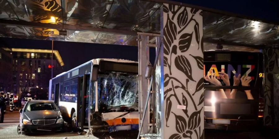 Ein beschädigter Pkw und ein beschädigter Bus stehen nach dem Unfall am Wiesbadener Hauptbahnhof. Foto: Michael Ehresmann/Wiesbaden112/dpa