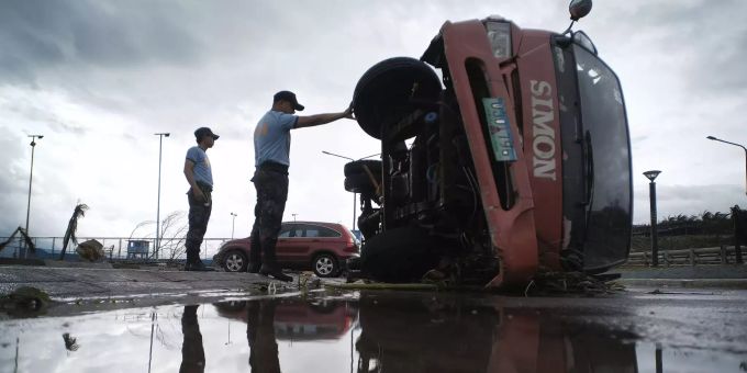 Die Polizei inspiziert in Legazpi einen umgestürzten Lkw. Philippinen Taifun Kammuri