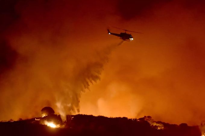 Ein Hubschrauber ist bei einem Waldbrand im Einsatz. Nach absichtlichen Stromabschaltungen wegen erhöhter Waldbrandgefahr haben in Nordkalifornien Hunderttausende Menschen im Dunkeln gesessen. Waldbrände in Kalifornien