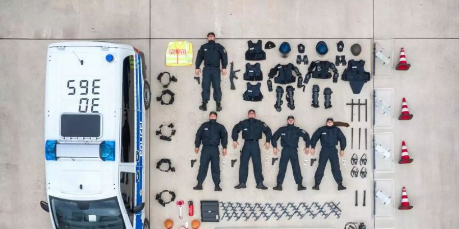 Das von der Bundespolizei zu Verfügung gestellt Foto zeigt Polizisten der Bundespolizei Duderstadt und ihre Ausrüstungsgegenstände neben einem Polizeifahrzeug. Unter dem Hashtag #TetrisChallenge finden sich in den sozialen Medien viele Bilder, die das ausgeräumte Innenleben von Fahrzeugen jeglicher Art zeigen. Foto: Sebastian Grafe/Bundespolizei/Handout