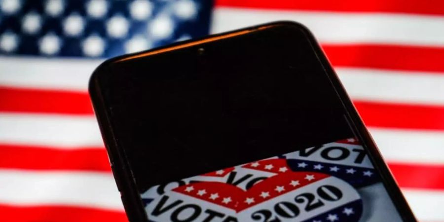 Die US-Wahl auf einem Smartphone-Bildschirm. Foto: Herwin Bahar/ZUMA Wire/dpa