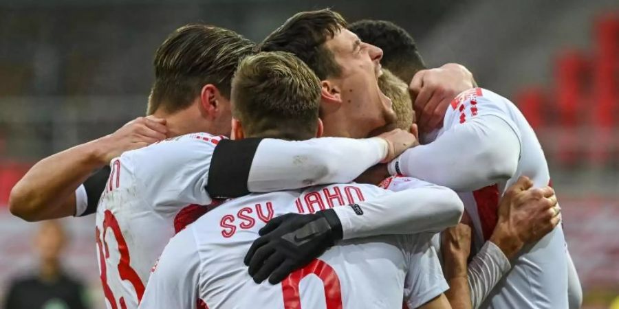 Die Mannschaft von Regensburg feiert ihren späten Sieg gegen Würzburg. Foto: Armin Weigel/dpa