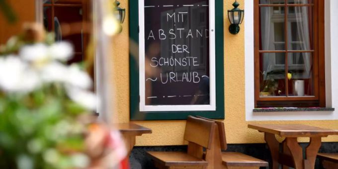 Eine Tafel mit der Aufschrift «Mit Abstand der schönste Urlaub» in Österreich. österreich