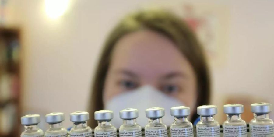 Ein Mitarbeiterin eines mobilen Impfteams in Halberstadt hält ein Tablett mit Impffläschchen der Firma Biontech/Pfizer. Foto: Matthias Bein/dpa-Zentralbild/dpa