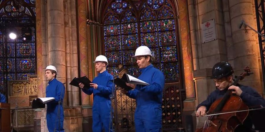 Der Cellist Gautier Capucon (r) und der Chor der Kathedrale Notre Dame zeichnen ein Weihnachtskonzert auf. Foto: Musique Sacree à Notre-Dame de Paris/MSNDP/AP/dpa