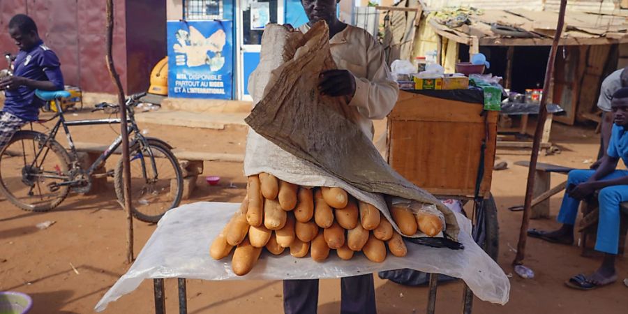 dpatopbilder - Ein Mann verkauft auf einem Markt französisches Baguette. Die Afrikanische Union (AU) unterstützt die von der westafrikanischen Staatengruppe Ecowas gefassten Massnahmen zur Wiederherstellung der verfassungsmässigen Ordnung im Niger. Das teilte der AU-Vorsitzende Faki Mahamat mit. Foto: Sam Mednick/AP