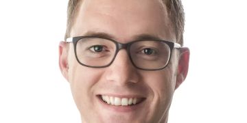 Mann mit Brille und kurzen Haaren im Anzug