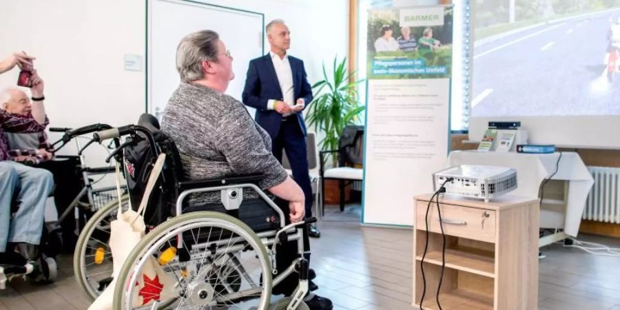 Ingelore Leppin, Bewohnerin im Alten- und Pflegeheim Heinemanhof, fährt mit der speziell für Ältere entwickelte Spielekonsole «MemoreBox» auf einem Motorrad. Foto: Hauke-Christian Dittrich