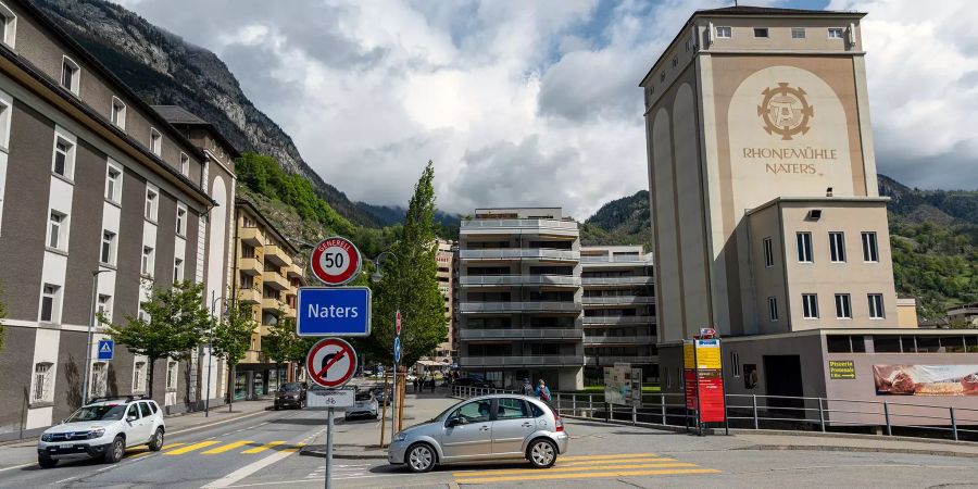 Strassenschild von Naters an der Bahnhofstrasse und rechts das Gebäude der Rhonemühle.