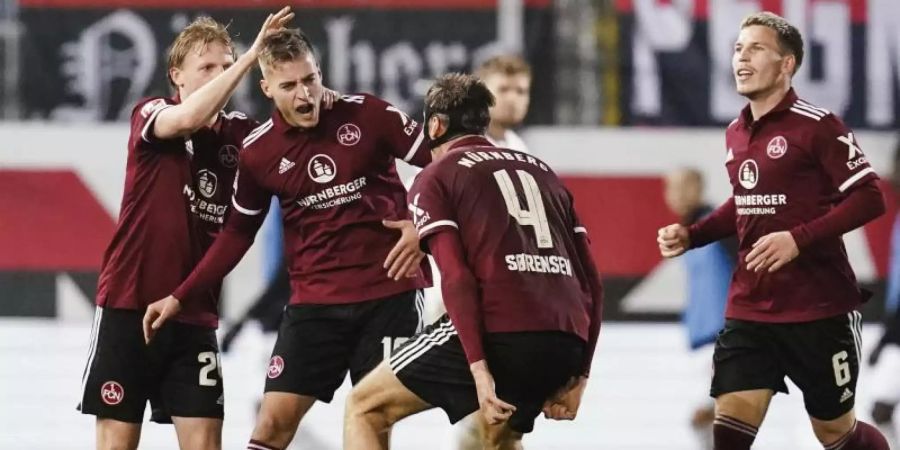Nürnbergs Torschütze Fabian Nürnberger (2.v.l.) jubelt mit Manschaftskollegen über das Tor zum 1:1-Ausgleich. Foto: Uwe Anspach/dpa