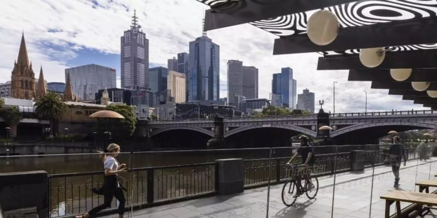 Menschen joggen entlang der Southgate in Melbourne. Gut eineinhalb Jahre nach Beginn der Corona-Pandemie hat die australische Millionenmetropole einen unrühmlichen Rekord aufgestellt: 246 Tage im Lockdown-Modus. Foto: Daniel Pockett/AAP/dpa