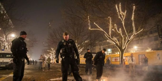 Polizisten in Berlin treten kleine Brände aus. silvester