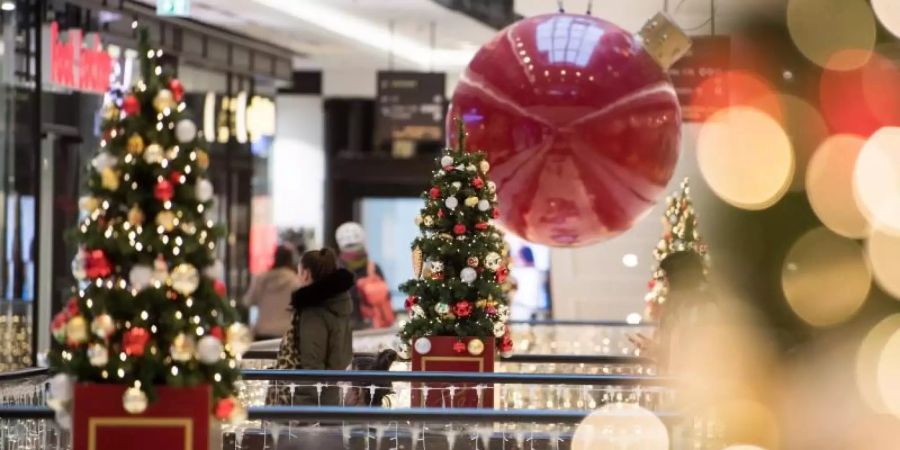 Kunden schlendern durch ein weihnachtlich geschmücktes Einkaufszentrum in Berlin. Foto: Bernd von Jutrczenka/dpa