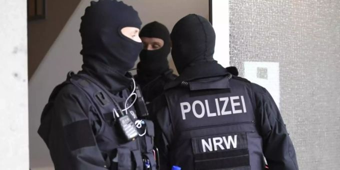 Polizisten durchsuchen ein Gebäude in Düsseldorf beim landesweiten Polizeieinsatz gegen Geldwäsche und Terrorfinanzierung. Foto: Roberto Pfeil/dp/dpa Polizisten durchsuchen ein Gebäude in Düsseldorf beim landesweiten Polizeieinsatz gegen Geldwäsche und Terrorfinanzierung. Foto: Roberto Pfeil/dp/dpa