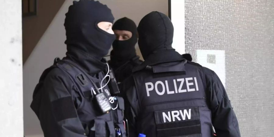 Polizisten durchsuchen ein Gebäude in Düsseldorf beim landesweiten Polizeieinsatz gegen Geldwäsche und Terrorfinanzierung. Foto: Roberto Pfeil/dp/dpa