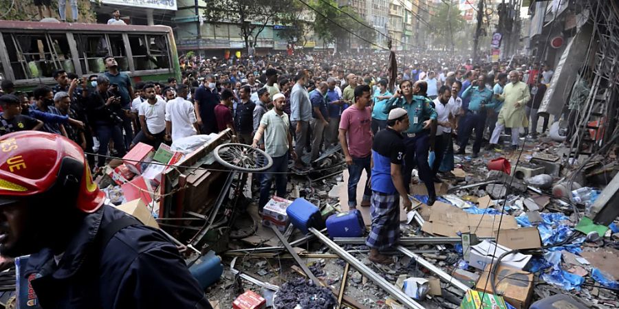 Menschen versammeln sich vor dem Ort einer Explosion. Bei einer Explosion in einem fünfstöckigen Gebäude in Bangladesch sind mindestens 15 Menschen getötet und Dutzende verletzt worden. Foto: -/AP/dpa