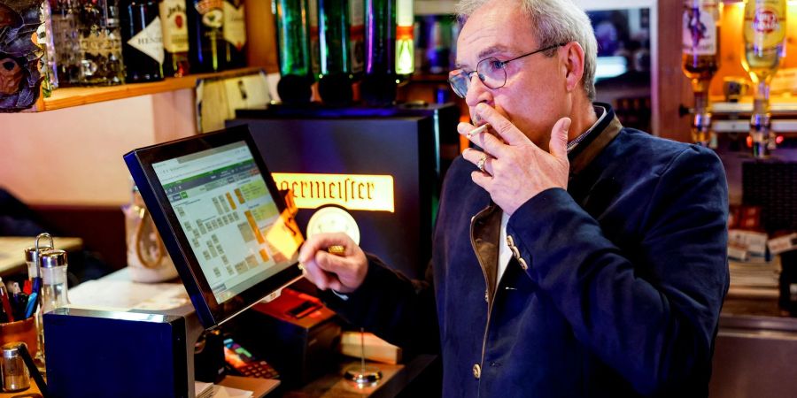 Peter Krall, Inhaber des «Hofbräu Raucher Stüberl» in Hamburg, raucht am Tresen seines Lokals eine Zigarette.