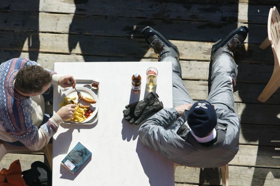 Fleisch bleibt in den Bergen dennoch der Favorit: Ein Mann isst Pommes mit Wienerli in Davos GR. (Archivbild)