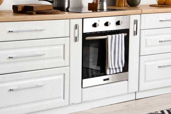 Moderne Küche in Weiss mit Küchenschränken und Backofen