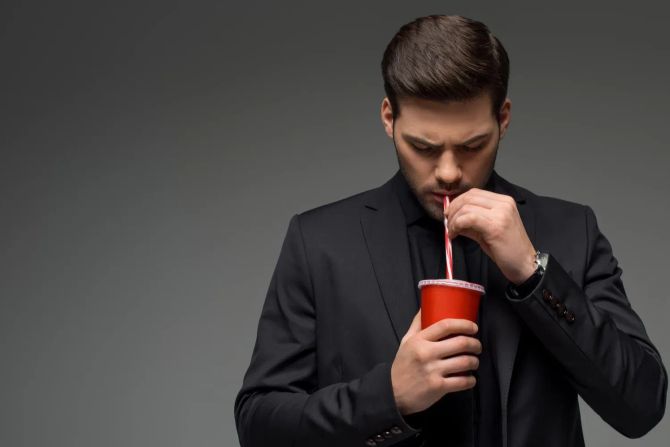 mann trinkt cola, grauer hintergrund