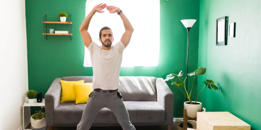 Mann Jumping Jacks Wohnzimmer Hampelmänner