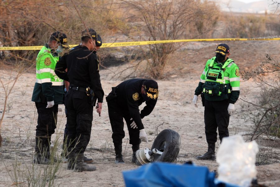 Polizisten untersuchen einen abgerissenen Reifen des abgestürzten Kleinflugzeugs an der Absturzstelle in der Provinz Nasca.