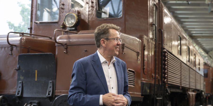 Bundesrat Albert Rösti spricht vor einer Lokomotive im Verkehrshaus Luzern über das grosse Ausbauprojekt «Verkehr '45».