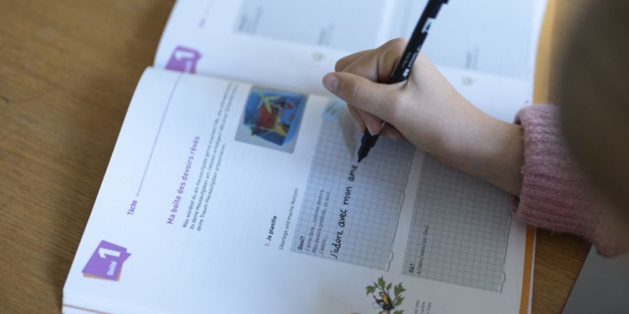 Ein Mädchen macht zu Hause ihre Französischaufgaben. Die Zukunft des Französischunterrichts beschäftigt auch die Zuger Politik. (Symbolbild)