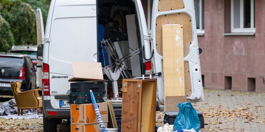Möbel und Umzugskartons stehen vor einem Transporter an einem Wohnhaus in Leipzig. (Symbolbild)