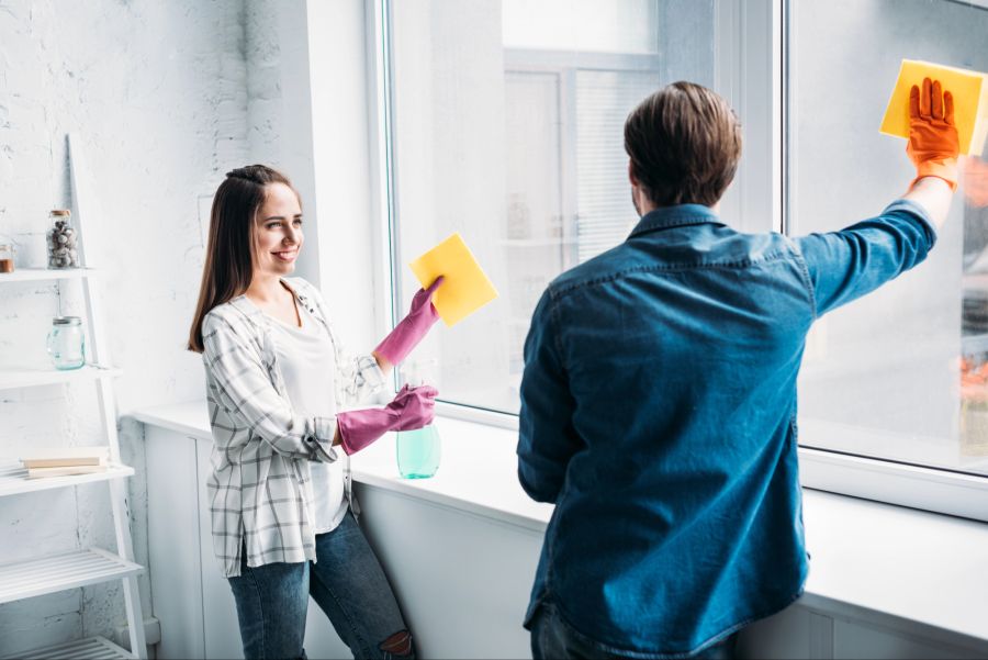 Mann und Frau fröhlich beim Fensterputzen