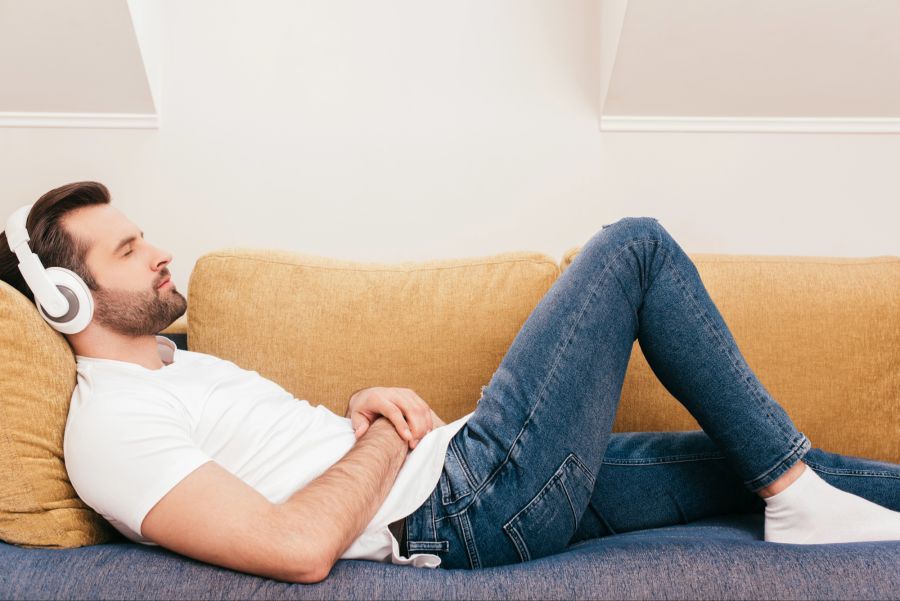 Mann mit Kopfhörern auf dem Sofa