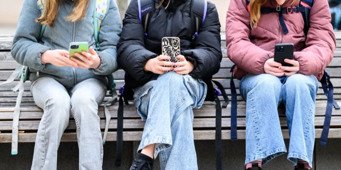 Schülerinnen mit einem Handy