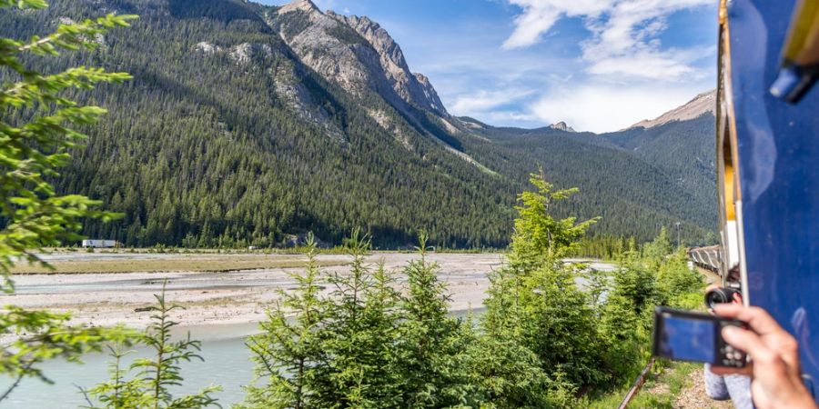 Zugfenster Ausblick Rocky Mountains Berge Fluss Hand Smartphone Bild