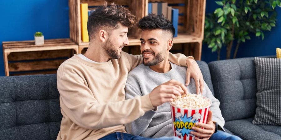 Pärchen Männer Couch Popcorn tiefe Blicke