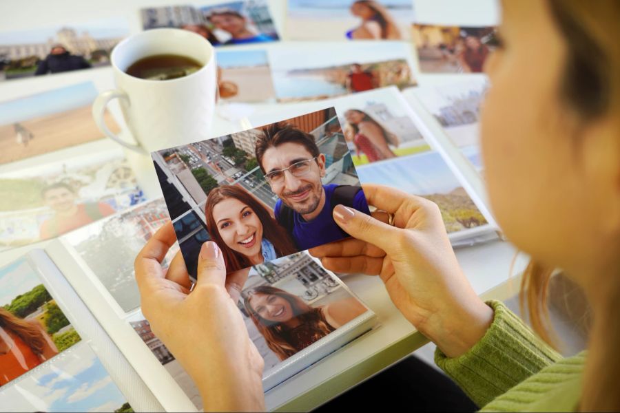 Frau betrachtet Pärchenfotos.