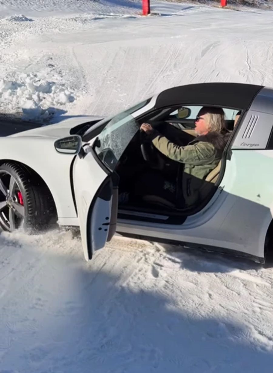 Dr TV-Millionär sitzt in seinem Porsche. Der Wagen ist im Schnee festgefahren.