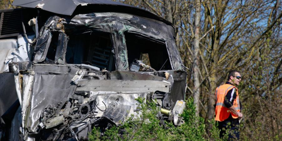 Ein Arbeiter steht in der Nähe eines Hochgeschwindigkeitszuges (TGV), nachdem dieser in Bully-les-Mines mit einem Laster zusammengestoßen ist. Foto: Jean-Francois Badias/AP/dpa
