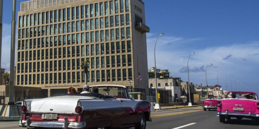 ARCHIV - Touristen fahren in klassischen Cabriolets auf dem Malecon an der Botschaft der USA vorbei. Foto: Desmond Boylan/AP/dpa